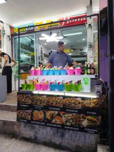 a man is standing behind a food stand at Haadrin Fellini Home in Haad Rin