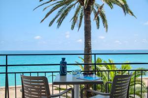 a table and chairs with a view of the ocean at Best Western Premier Hotel Prince de Galles in Menton