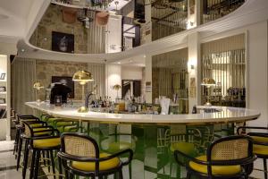 a bar with yellow and green chairs in a restaurant at Best Western Premier Hotel Roosevelt in Nice
