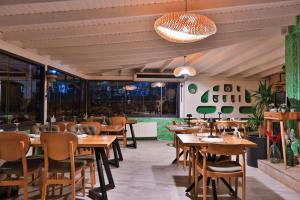 a restaurant with wooden tables and chairs at Livadi Jur in Akçakoca