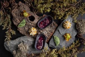 two bowls of food sitting on rocks with plants at Hotel Le K2 Altitude in Courchevel
