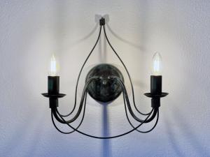 a chandelier with two candles hanging on a wall at Sonnenhof Seeg 08 in Seeg