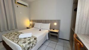 a hotel room with a bed and a night stand at Abbeville Hotel Torre I - Torre II in São Luís