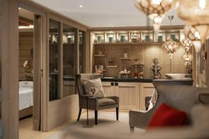 a living room with a chair and a kitchen at Hotel Le K2 Altitude in Courchevel +22 photos