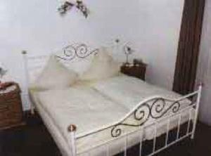 a white bed with white sheets and pillows at Kämpgens – Hof in Mülheim an der Ruhr