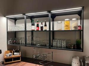 a shelf with bottles of wine and glasses on it at Møn Klintholm Vintage B&B in Borre