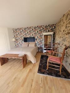 a bedroom with a bed and a table and a chair at Aumônerie du Prieuré in Pouzauges