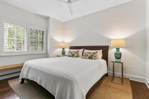 a white bedroom with a large bed and two lamps at 4956 Green Dolphin in Kiawah Island