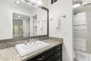 a white bathroom with a sink and a mirror at 5537 Green Dolphin Way in Kiawah Island +24 photos