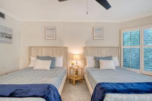 a bedroom with two beds and a table with a lamp at 5537 Green Dolphin Way in Kiawah Island