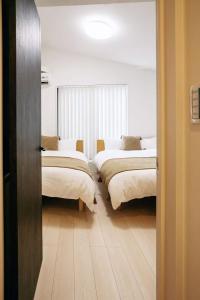 a room with three beds with white sheets on them at Tokyo stay 365 in Tokyo