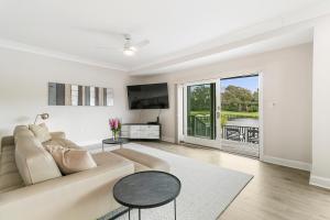 a white living room with a couch and a tv at 4910 Green Dolphin in Kiawah Island