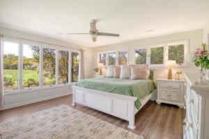 a white bedroom with a bed and windows at 273 Summer Tanager in Kiawah Island