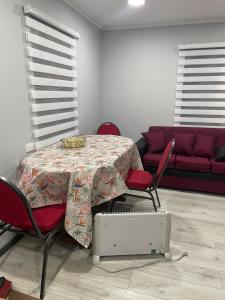 a dining room with a table and chairs and a couch at departamento central in Valdivia