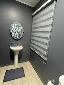 a bathroom with a sink and a mirror at departamento central in Valdivia