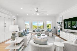a living room with white furniture and a tv at 38 Surfsong in Kiawah Island