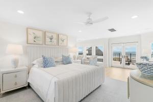 a white bedroom with a bed and a table at 38 Surfsong in Kiawah Island +92 photos
