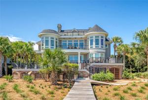 a large house with palm trees and a wooden walkway at 38 Surfsong in Kiawah Island