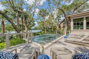 a patio with a pool and chairs and a house at 68 New Settlement in Kiawah Island