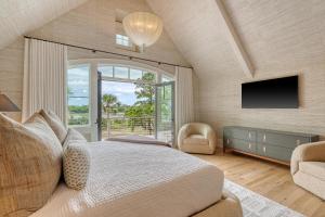 a bedroom with a large bed and a tv at 135 Halona Ln in Kiawah Island