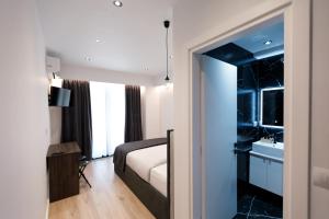 a hotel room with a bed and a bathroom at Silver Stone Studio Apartments in Gjirokastër