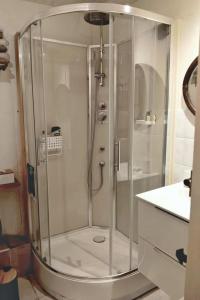 a shower with a glass door in a bathroom at Escale Zen en Quercy in Montalzat