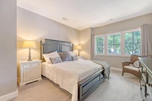 a bedroom with a bed and a chair and windows at 4925 Green Dolphin in Kiawah Island