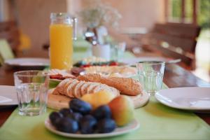 a table with plates of food and glasses of orange juice at Borbála Vendégház in Füzér +36 photos