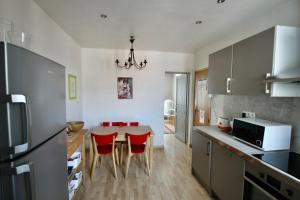 a kitchen with a table and red chairs in it at Studio de Rêves -SV245- Centre Vincennes in Vincennes