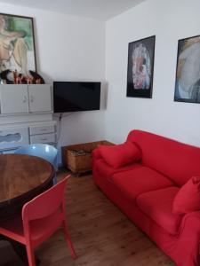 ein Wohnzimmer mit einem roten Sofa und einem Tisch in der Unterkunft Villinolapieve in Castelfiorentino