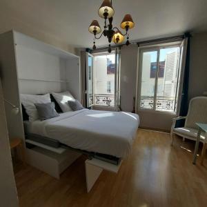a bedroom with a large white bed and a window at Studio de Rêves -SV245- Centre Vincennes in Vincennes