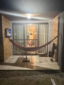 a hammock in the middle of a living room at Apartamento em Resort para família in Barra de São Miguel
