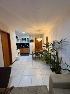 a living room with a table and a kitchen at Apartamento em Resort para família in Barra de São Miguel