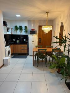 a kitchen with a table and chairs and a refrigerator at Apartamento em Resort para família in Barra de São Miguel +2 photos