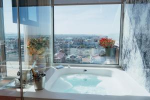 a bath tub in a bathroom with a window at Hotel Costa Verde in Póvoa de Varzim +46 photos