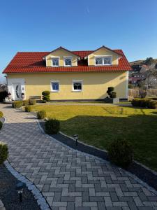 a large yellow house with a red roof at Heimglück mit Ipf & Ruine in Bopfingen