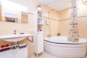 a bathroom with a tub and a sink and a toilet at Residencial Suites Valldemossa - Turismo de Interior in Valldemossa +34 photos