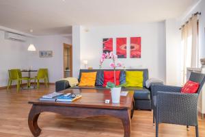 a living room with a couch with colorful pillows at Residencial Suites Valldemossa - Turismo de Interior in Valldemossa