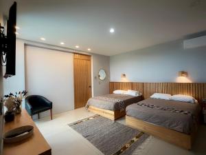 a bedroom with two beds and a table and a desk at "Casa Mosso" en San Felipe del Agua in Oaxaca City +61 photos