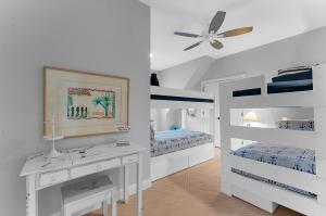 a white bedroom with two bunk beds and a ceiling fan at 711 Glossy Ibis in Kiawah Island +47 photos