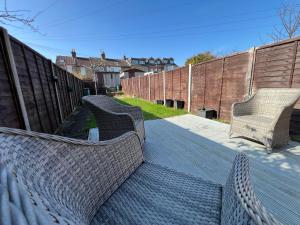 two wicker benches sitting on a patio at Victoria Maidstone Tranquil Retreat in Maidstone