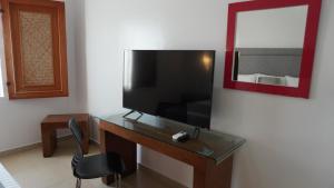 ein Schreibtisch mit Fernseher und Stuhl in einem Zimmer in der Unterkunft Zar Manzanillo in Manzanillo