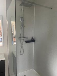 a shower in a bathroom with a glass door at L'Escale d'Omaha - Cottage de 50m2 in Saint-Marcouf +11 photos