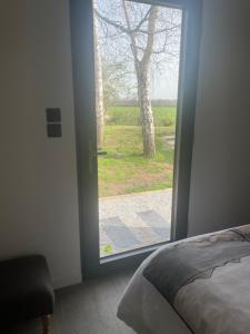 a bedroom with a door leading to a yard at L'Escale d'Omaha - Cottage de 50m2 in Saint-Marcouf