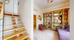 a living room with a staircase with books at Casa Nina in Gabicce Mare