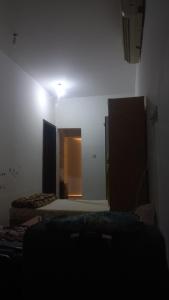 a room with two beds and a light on the wall at BRAZIL House in Muscat