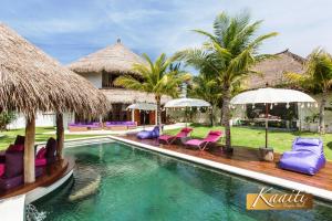 a pool at a resort with chairs and umbrellas at Villa Kaaiti in Uluwatu +18 photos