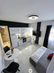 a bedroom with a bed and a table and a kitchen at Mediterranean Port Suite in Ágios Rókkos