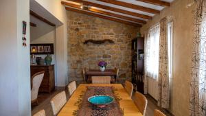 a dining room with a table and a stone wall at Igeldo in Orio