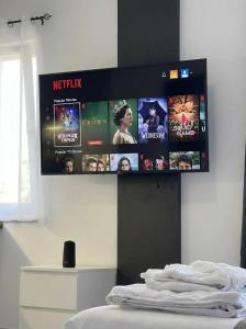 a tv hanging on a wall above a bed at Mediterranean Port Suite in Ágios Rókkos